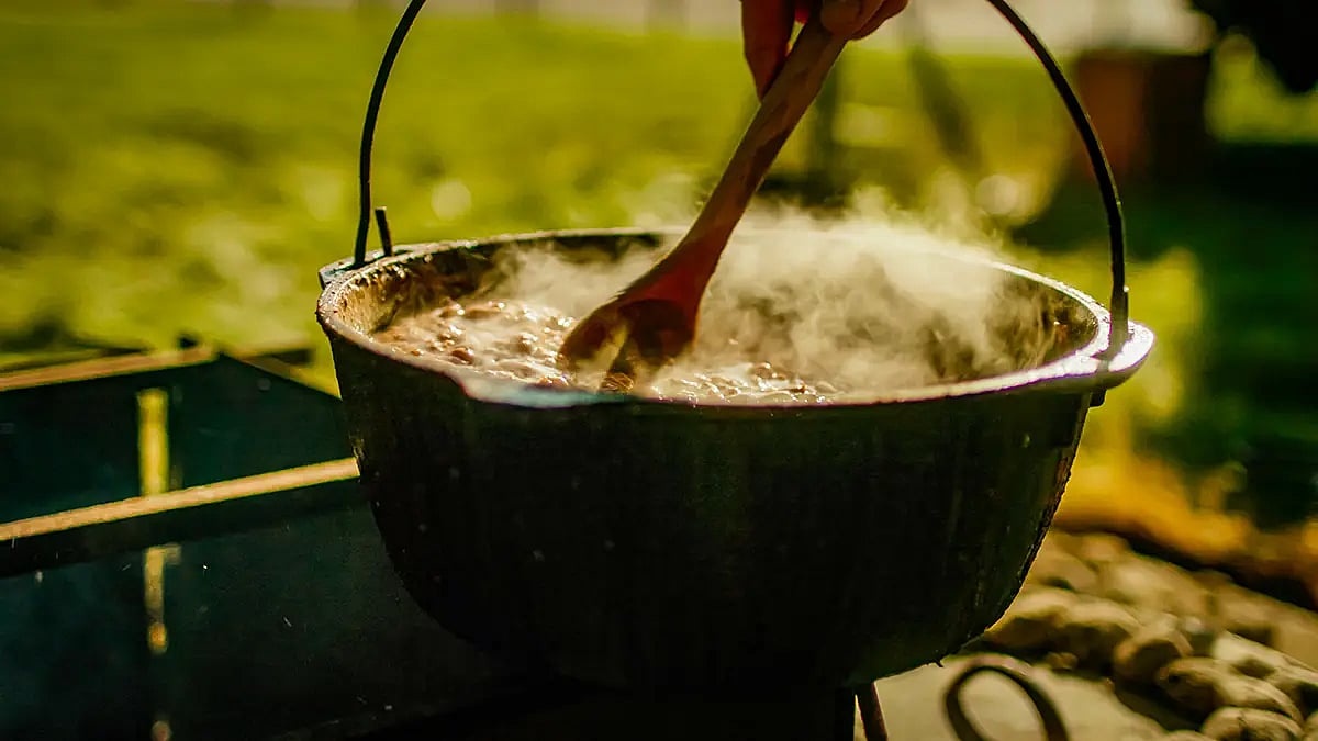 Stirring a steaming pot of Dutch Oven Beans
