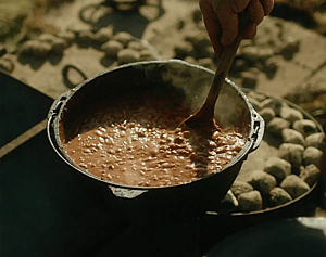Rich from 2 Mules stirring the dutch oven beans