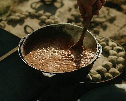 Rich from 2 Mules stirring the dutch oven beans